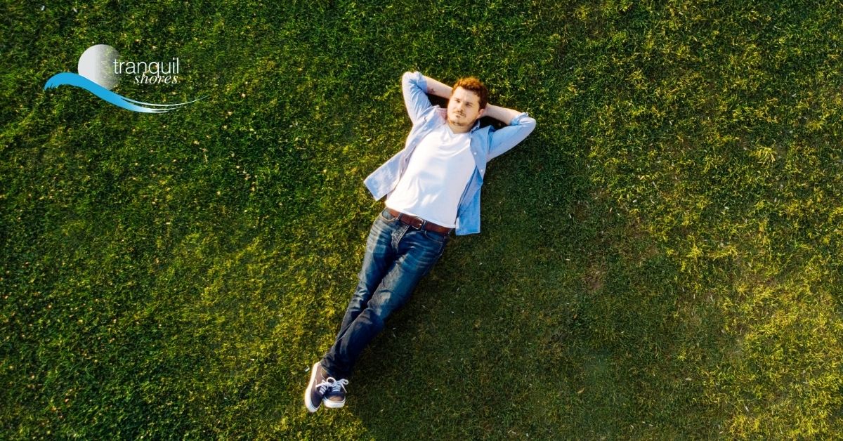 Man laying comfortable on the grass looking at the sky