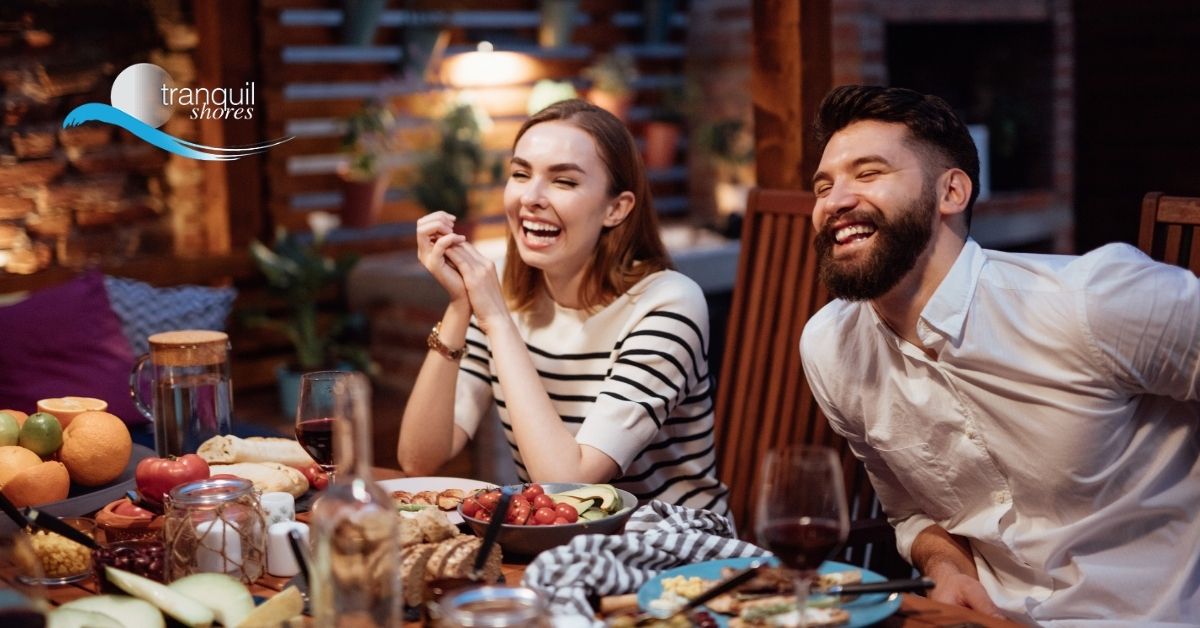 Couple laughing at the dinner table during holiday season