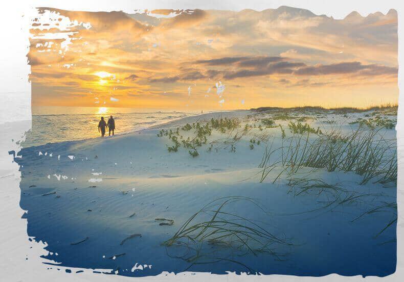 Two people walking along the sand at the beach