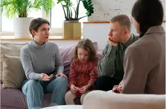 parents and child on couch